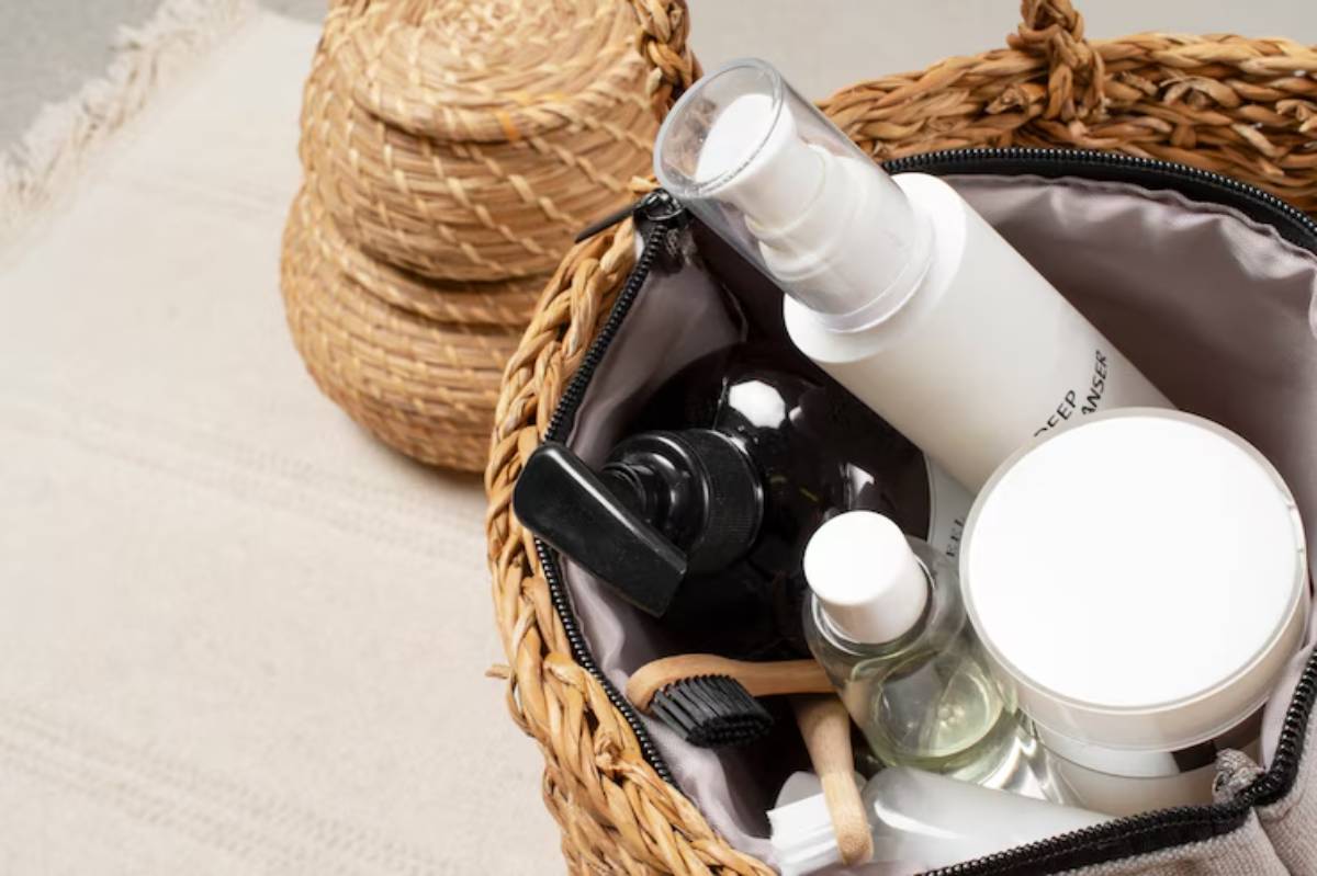 An open woven basket bag filled with various skincare products including bottles and jars, alongside natural wooden applicators.
