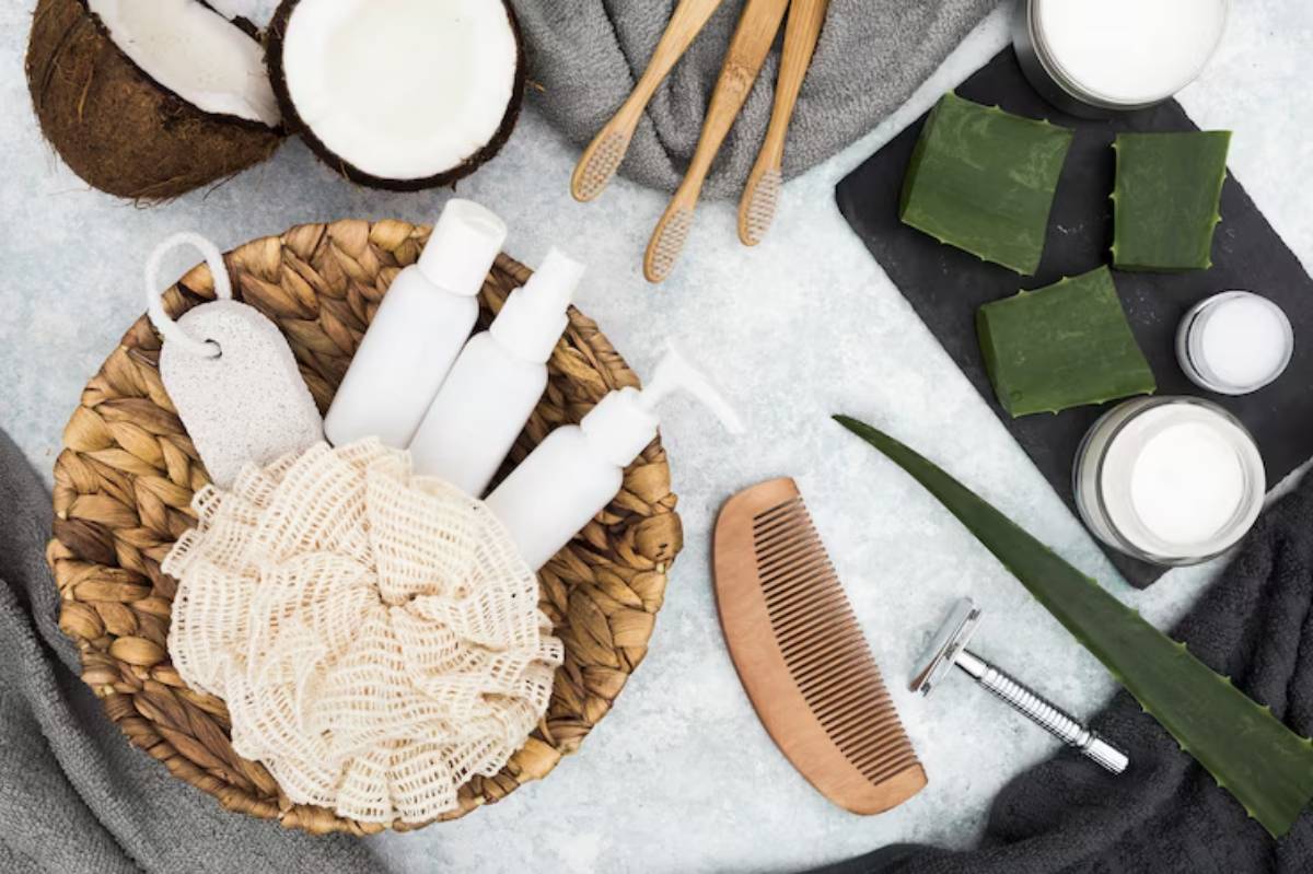 Natural skincare products arranged on a light surface, featuring coconut, aloe vera, wooden comb, and eco-friendly toiletries.