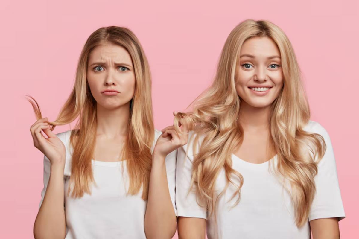 Two women with long hair, one straight and one wavy, both wearing white t-shirts, stand against a pink background.