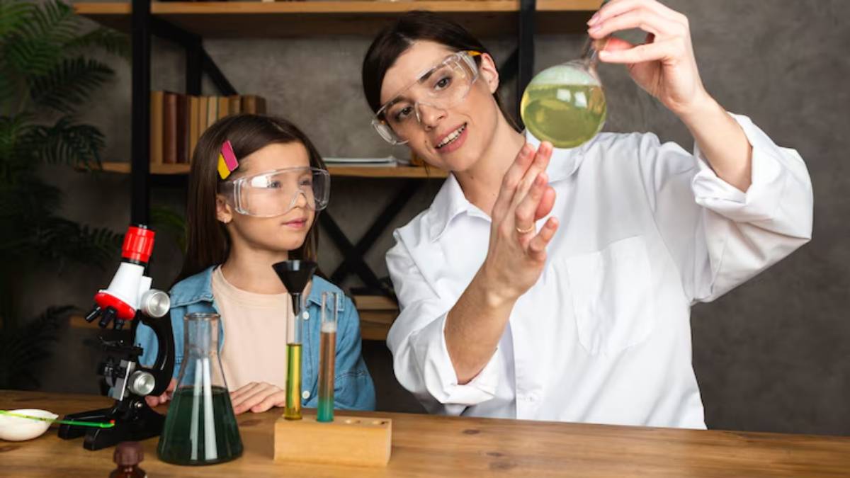 A person in a lab coat holds a flask with green liquid, while a child observes. Various scientific equipment is on the table.